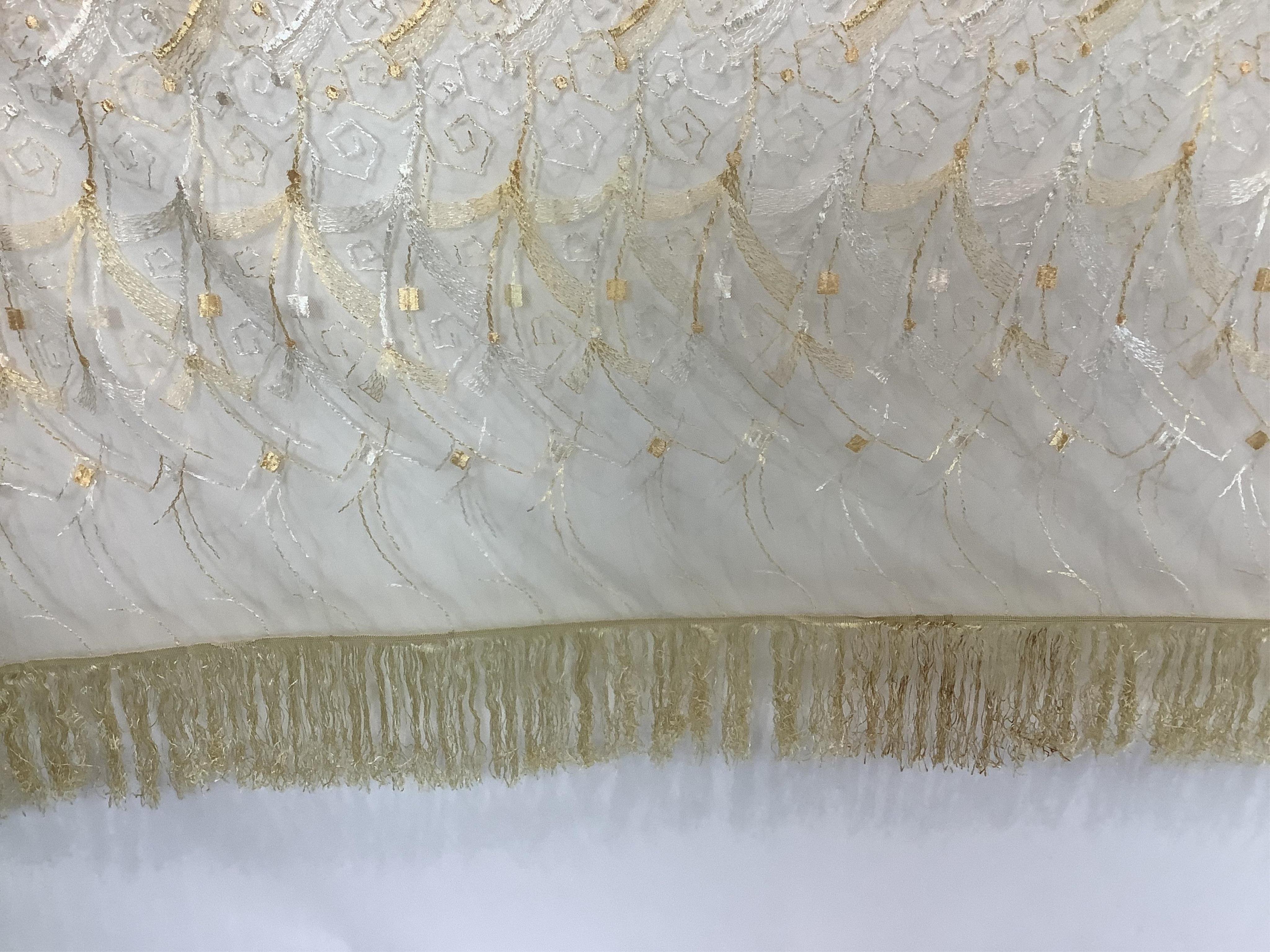 A French Art Deco wide silk yellow and cream embroidered net curtain, bordered at the bottom with yellow silk fringing. Approximately 560cm wide x 170cm long (not including fringing)., Condition - the curtain may need re